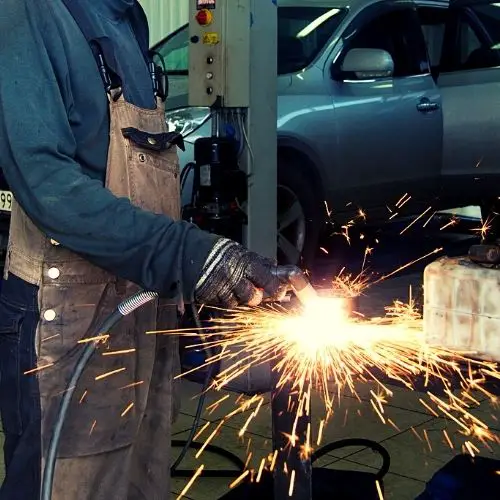 mechanic working on metal with a plasma cutter